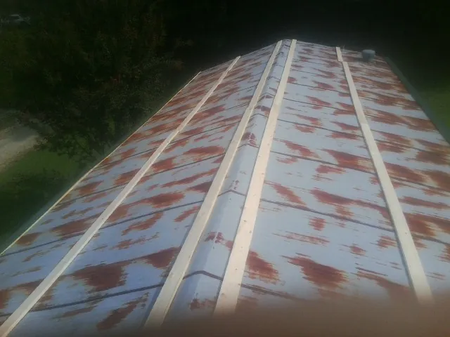 Rusted metal roof panels with new wood purlins before replacement — Storm Damage Roof Repair in Ovid by Roofing Brothers